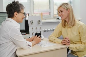 woman at an audiologist instead of getting OTC hearing aids