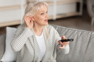 woman struggling to hear the TV with hearing aids in NoVA